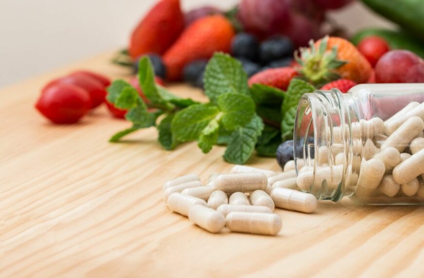 Supplement pills on table with fruit in background