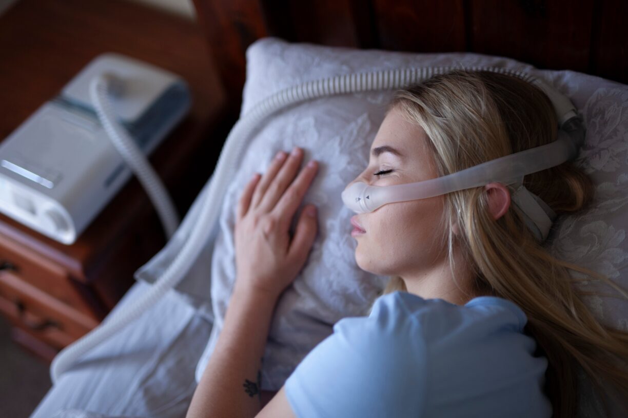 Young person, sleeping with cpap machine.