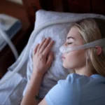 Young person, sleeping with cpap machine.