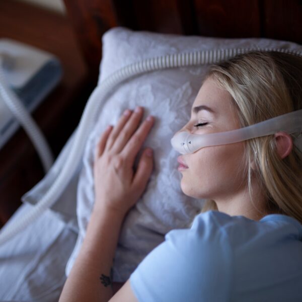 Young person, sleeping with cpap machine.