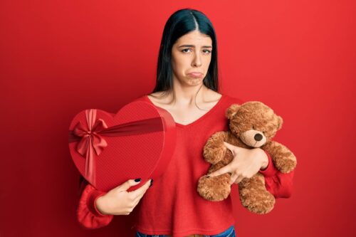 woman holding valentine gift depressed