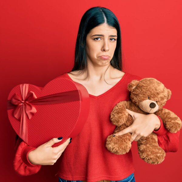 woman holding valentine gift depressed