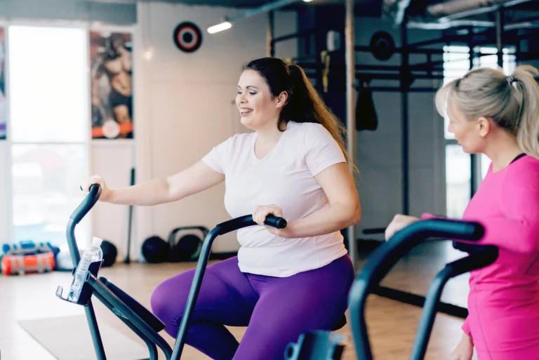 woman sits tired on stationary bike