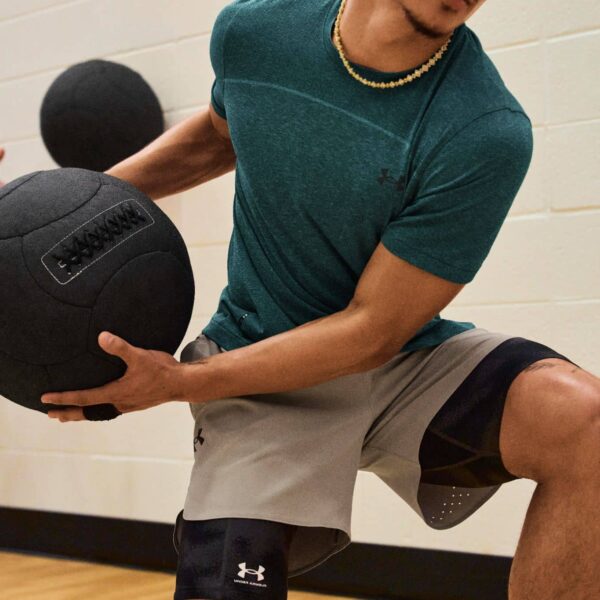 Fitness Person wearing Under Armour activewear throws medicine ball