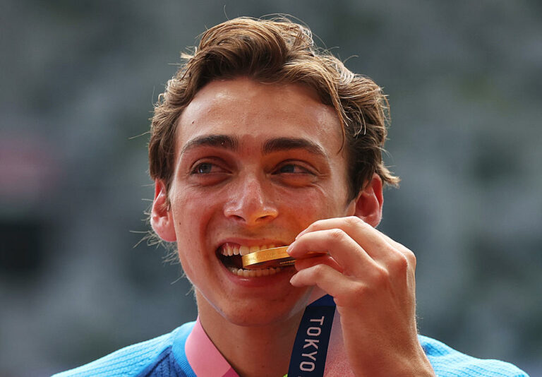 Olympian MONDO DUPLANTIS biting golf medal