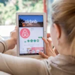 Woman is installing Airbnb application on Lenovo tablet.