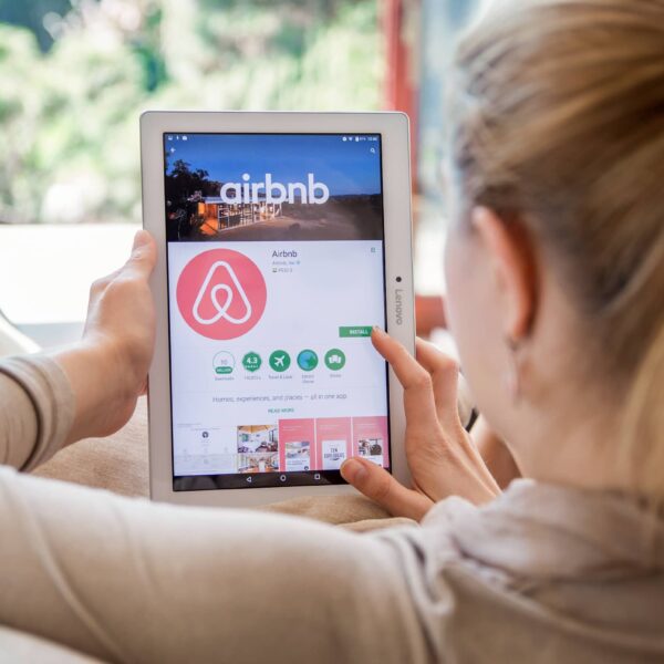 Woman is installing Airbnb application on Lenovo tablet.