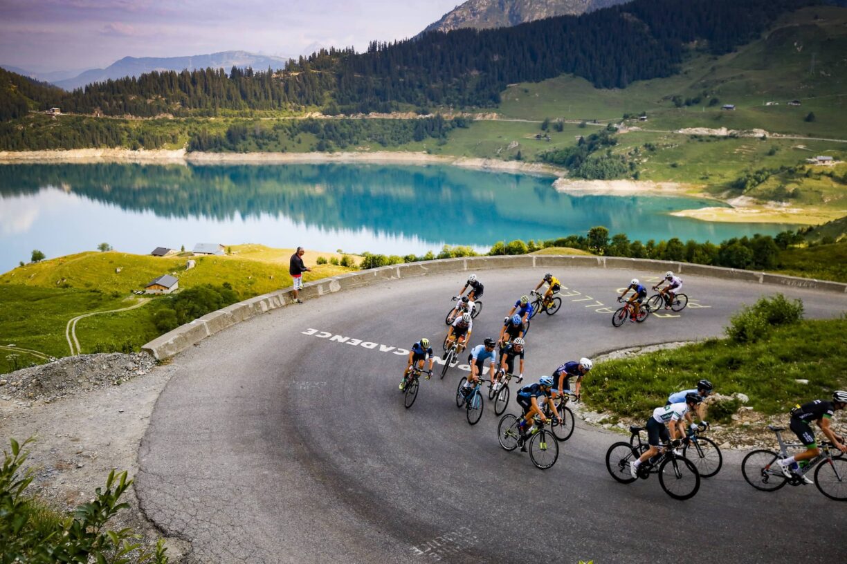 Cyclists heading up hill by lake