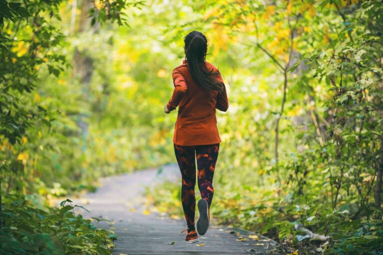 Run fit runner woman jogging in green spring forest woods park