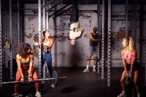 Escapologist Hanging Upside Down With Class Members Around