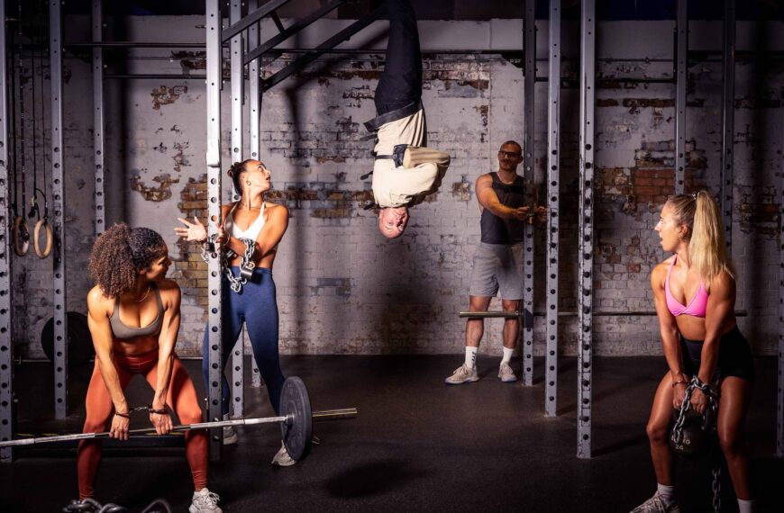 Escapologist Hanging Upside Down With Class Members Around