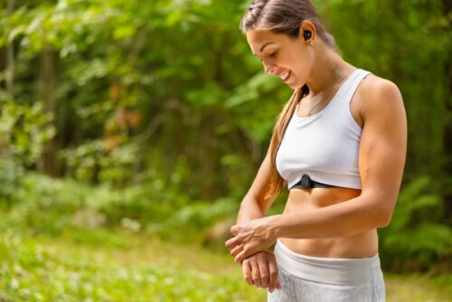 Well trained woman using fitness smart watch device under workout