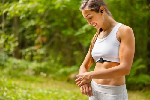 Well trained woman using fitness smart watch device under workout