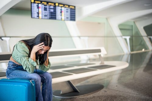 sad person at the airport because her flight has been canceled