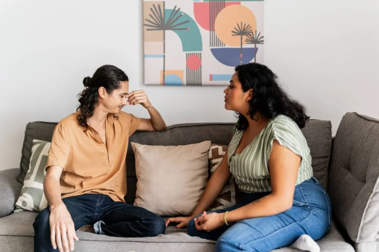 Friends talking to each other on sofa