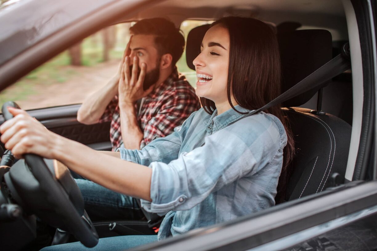 Man looks horrified as woman drives