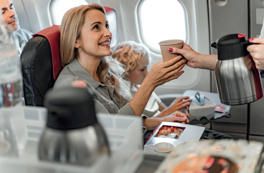 Smiling woman holding hot drink in plane