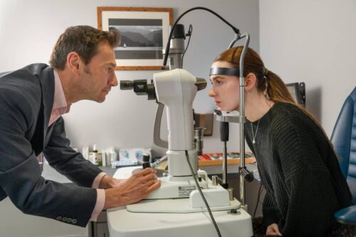 Optician looking into Patients eyes