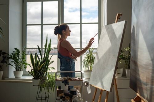 Thoughtful woman artist working on painting