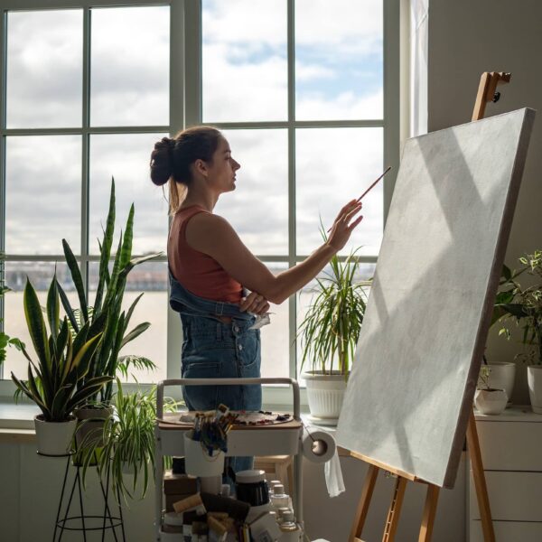 Thoughtful woman artist working on painting