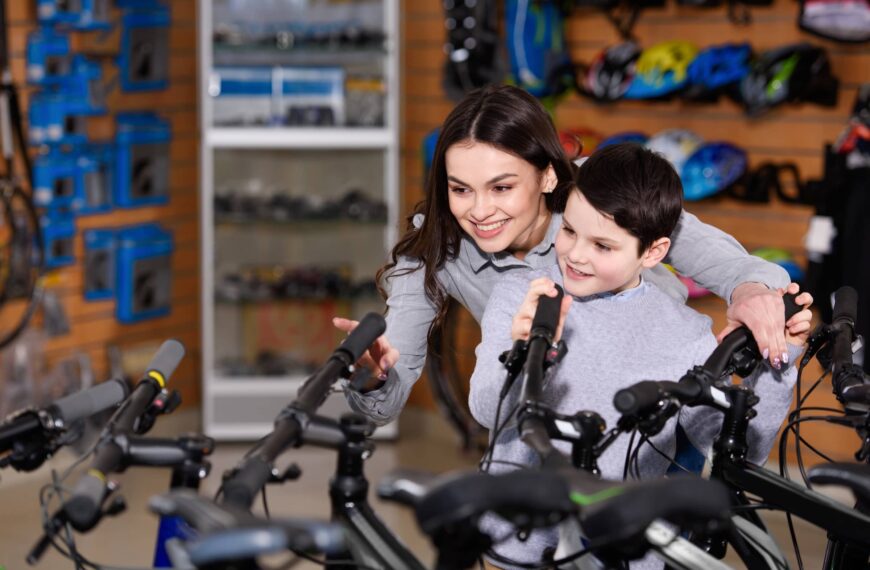 Young mother with son looking at bicycles in bike shop