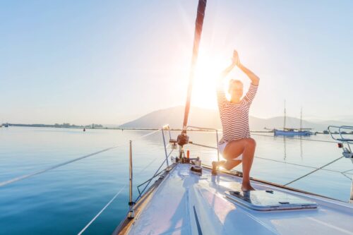 Girl practicing yoga on the deck of the yacht boat