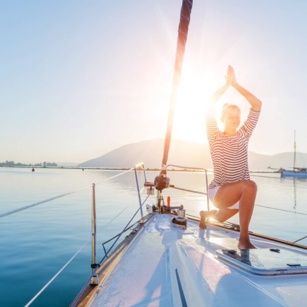 Girl practicing yoga on the deck of the yacht boat