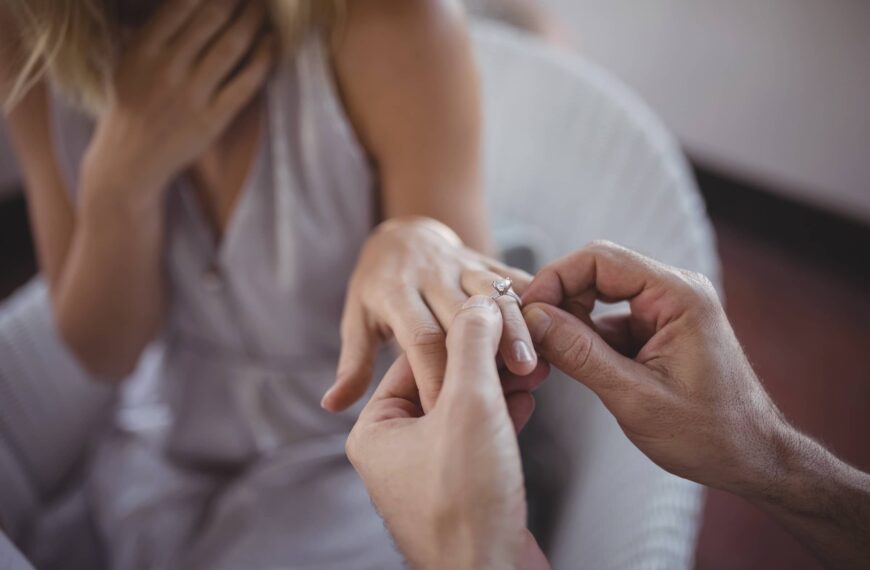 Man putting engagement ring on woman's hand