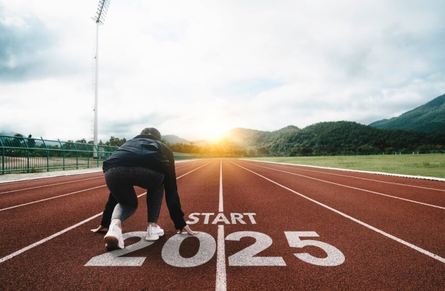 Word start 2025 written on athletics track and athlete woman runner preparing for new year at sunset