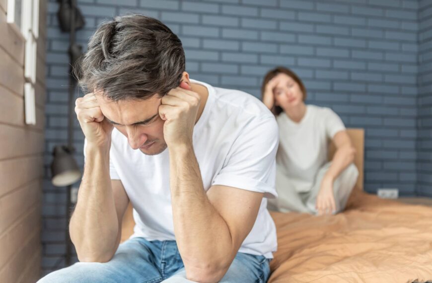 Frustrated and depressed man sitting on the edge of the bed after conflict with his wife because of his erectile dysfunction problem