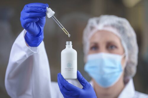 Scientist in lab mixing bottle