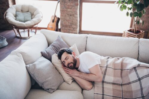 man lying on soft divan sleeping