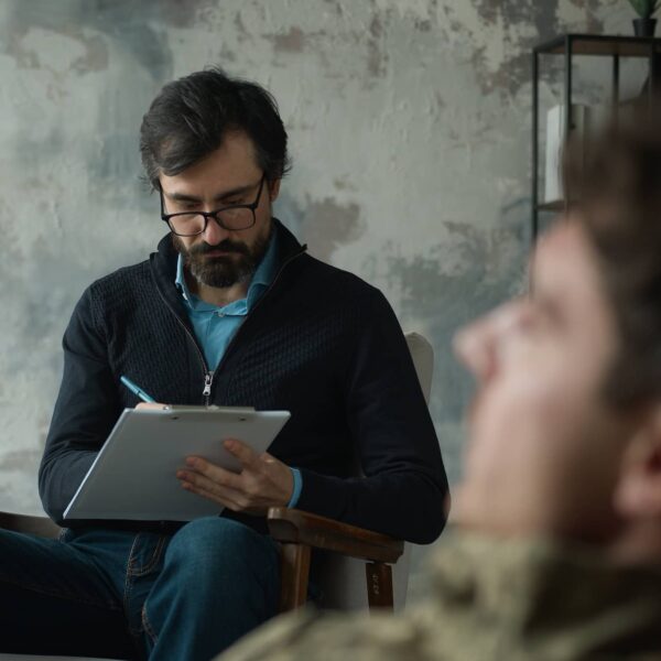 psychologist counselor writing notes listening patient client