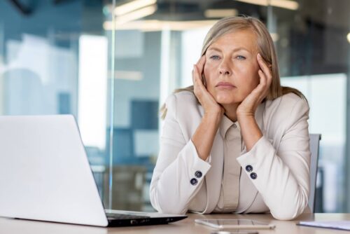 Sad unsatisfied senior woman at workplace