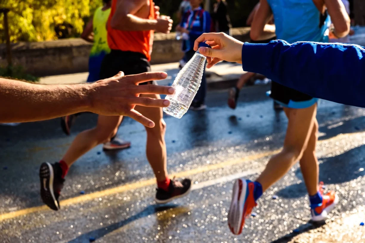 Runner collects a bottle of water to hydrate during a workout