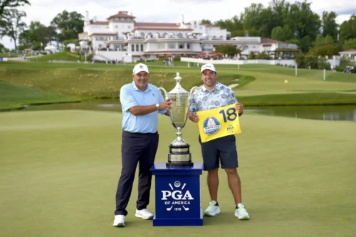 Angel Cabrera and his son and caddie, Angel Jr., pose with the Alfred S. Bourne Trophy after the Senior PGA Championship