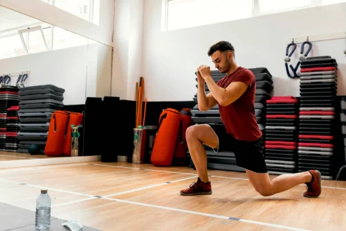 Man performs lunge in gym