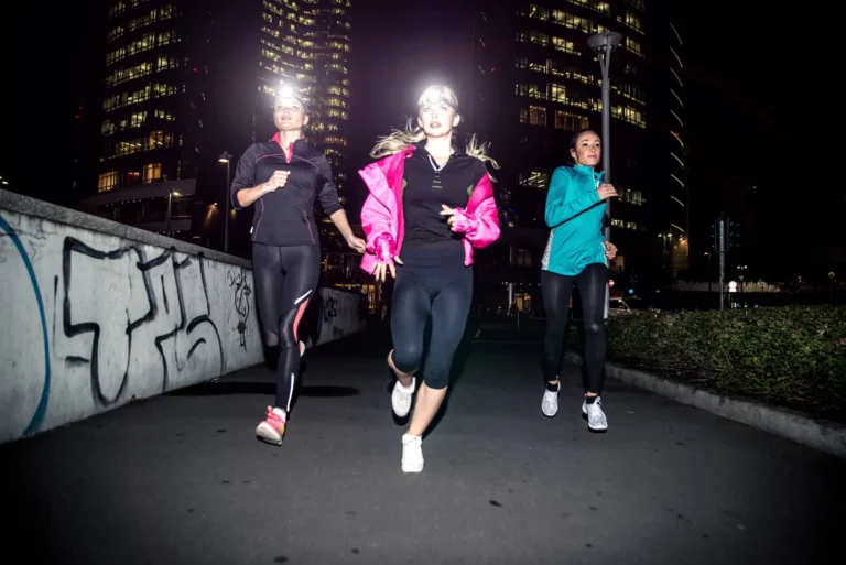 Three women running in the night in the city centre