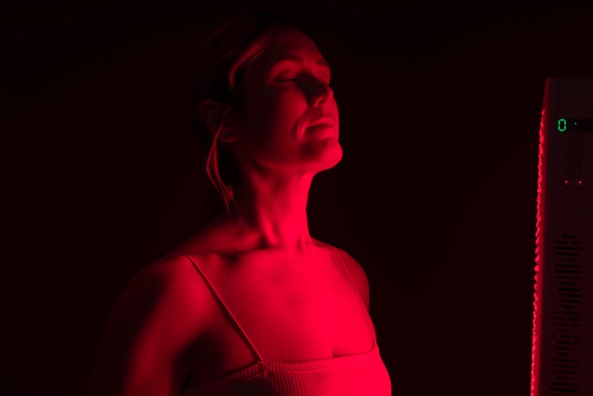 Woman getting red light therapy in a beauty salon. Mature woman getting anti-aging treatment from a red light device. Skin care and rejuvenation procedure.