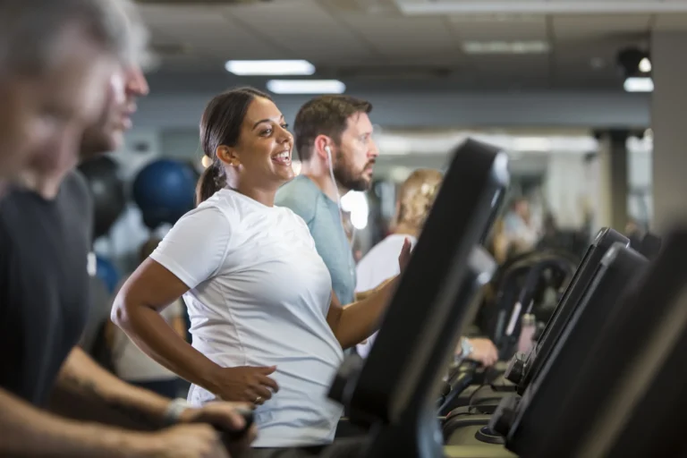 Woman smiles whilst on a treadmill