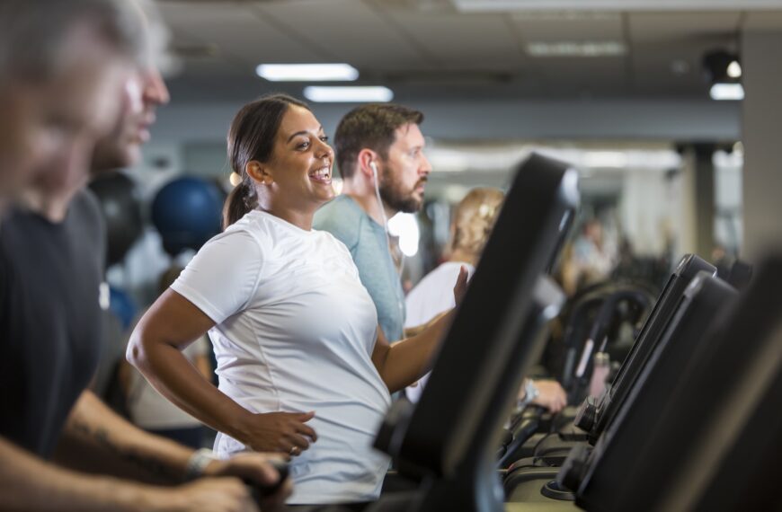Woman smiles whilst on a treadmill