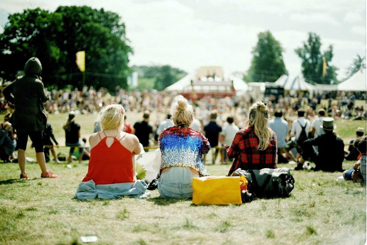 Festival goers sit listening to music