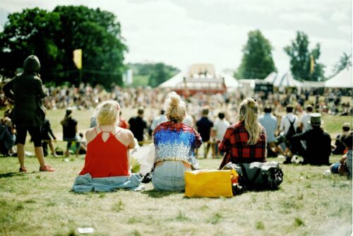 Festival goers sit listening to music