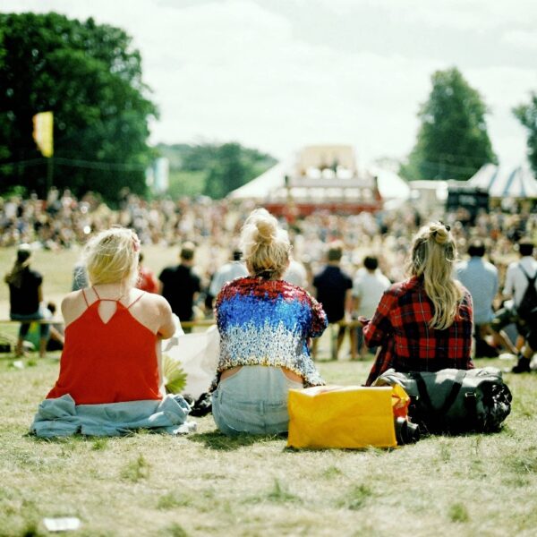 Festival goers sit listening to music