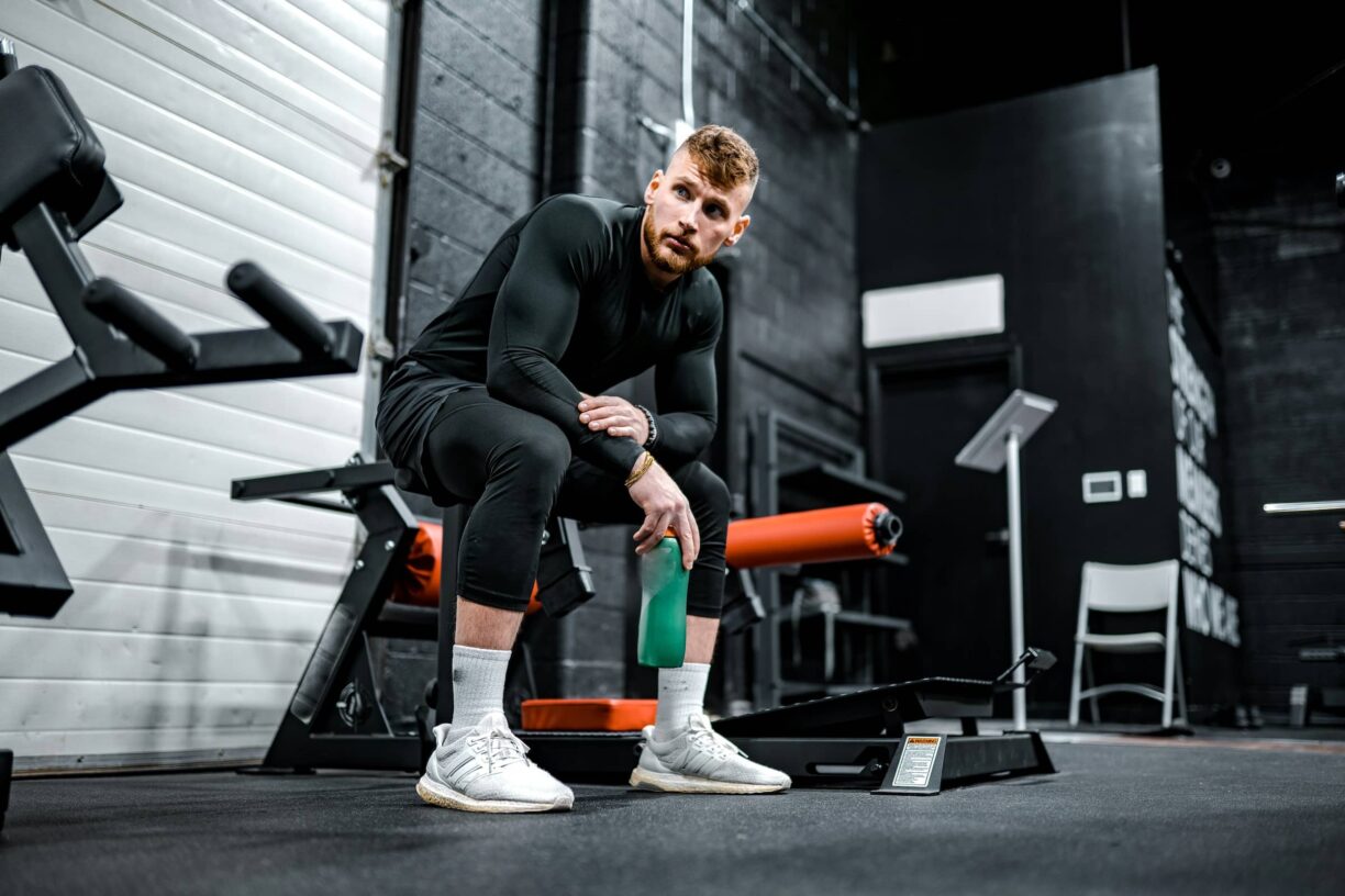 Man sits looking at gym equipment