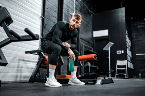 Man sits looking at gym equipment
