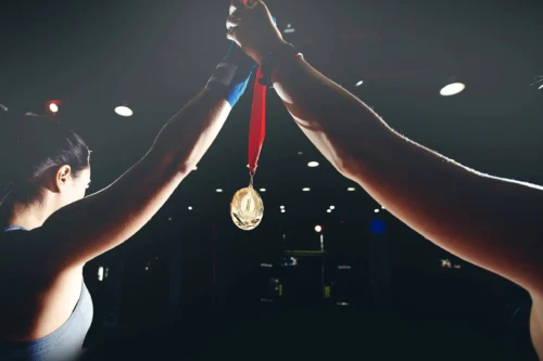 Medal held between two people