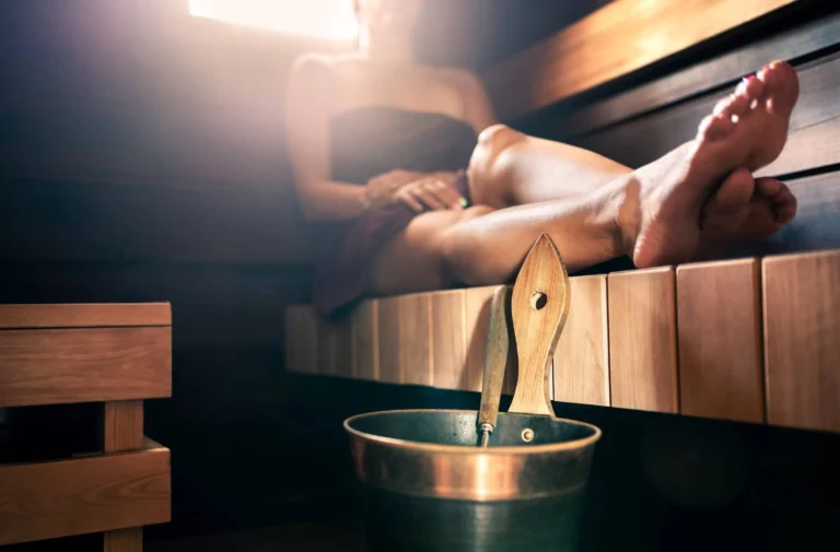 Water bucket and ladle. Towel on body, resting legs. Traditional Finnish lifestyle