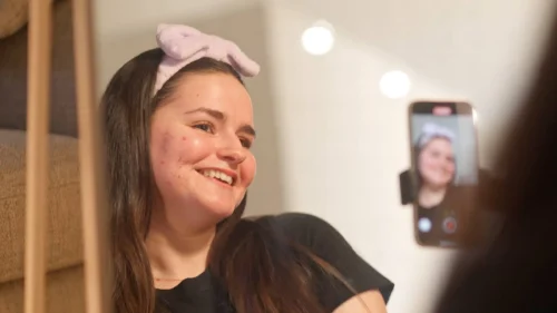 Young-person-smiles-to-phone-camera