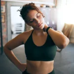 Shoulder pain and woman with an injury at gym after strength training or exercise